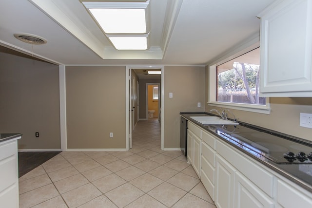 kitchen with sink, white cabinetry, light tile patterned floors, and black electric cooktop