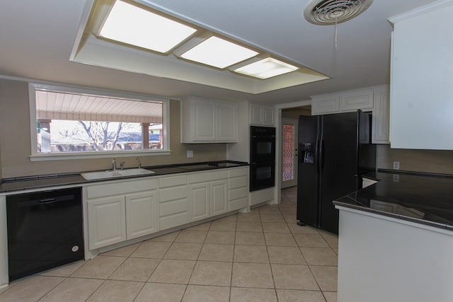 kitchen with black appliances, white cabinetry, light tile patterned floors, and sink