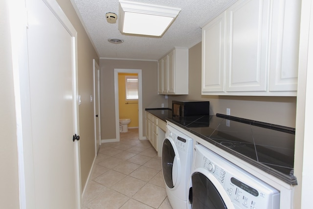 washroom featuring independent washer and dryer, a textured ceiling, and light tile patterned flooring