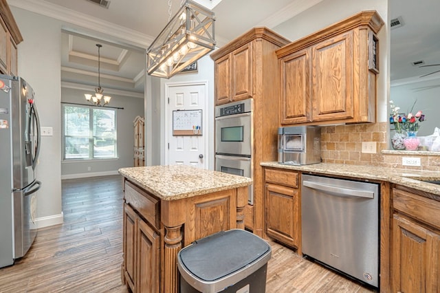 kitchen with appliances with stainless steel finishes, decorative backsplash, an inviting chandelier, and light wood-style flooring