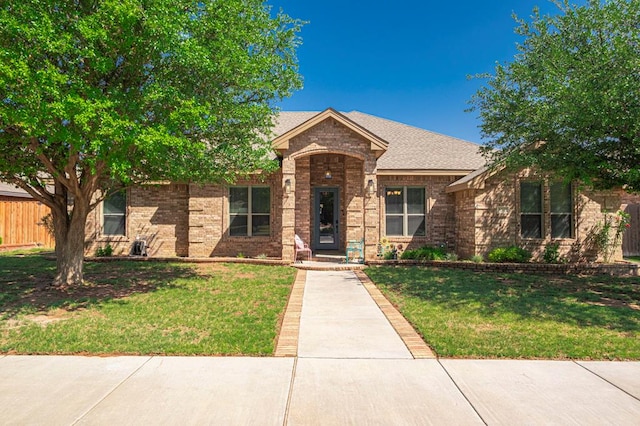view of front of property featuring a front lawn and brick siding