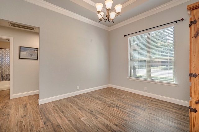 spare room featuring baseboards, a notable chandelier, wood finished floors, and visible vents