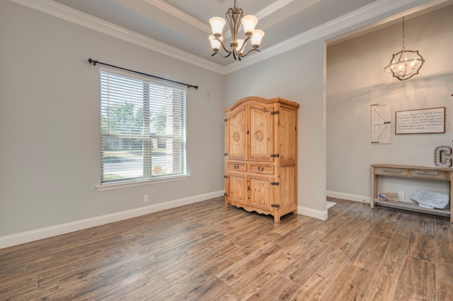 interior space with baseboards, ornamental molding, wood finished floors, and a notable chandelier