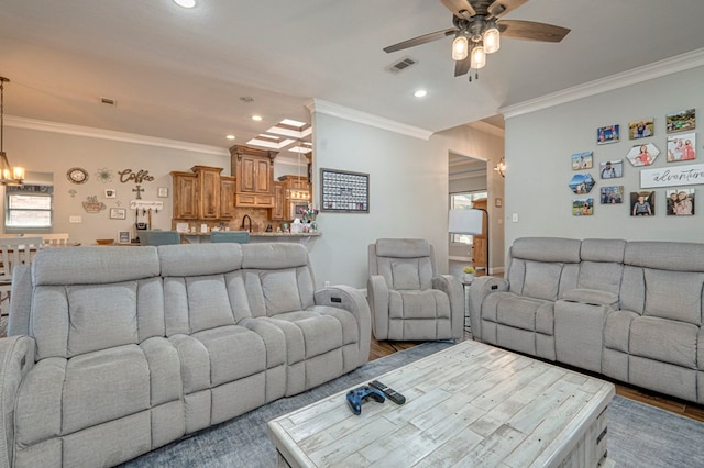 living area featuring visible vents, wood finished floors, ceiling fan with notable chandelier, ornamental molding, and recessed lighting