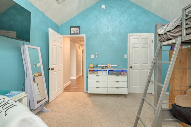 bedroom with carpet floors and lofted ceiling