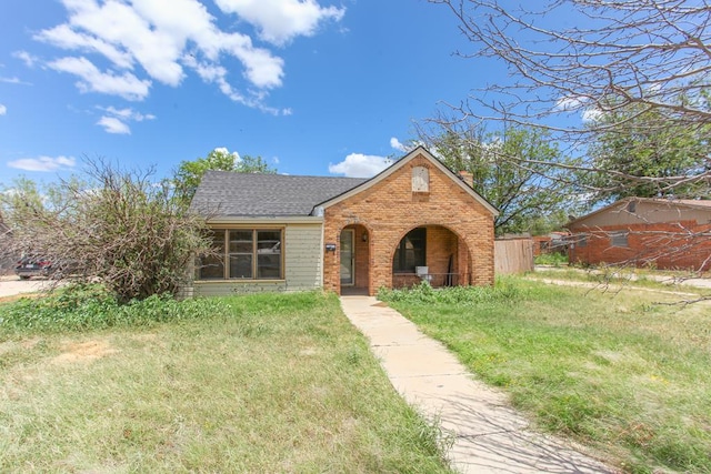1405 Runnels St, Big Spring, TX 79720 - view of front of house with brick siding, a chimney, roof with shingles, and a porch