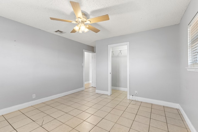 101 Waverly Dr, Midland, TX 79703 - unfurnished bedroom featuring a textured ceiling, light tile patterned flooring, a ceiling fan, and a closet