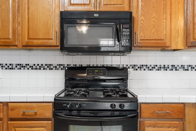 101 Waverly Dr, Midland, TX 79703 - kitchen with black appliances, tile countertops, decorative backsplash, and brown cabinets