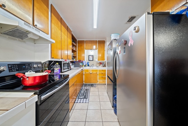 601 Caylor Dr, Big Spring, TX 79720 - kitchen with appliances with stainless steel finishes, under cabinet range hood, open shelves, light tile patterned floors, and light countertops