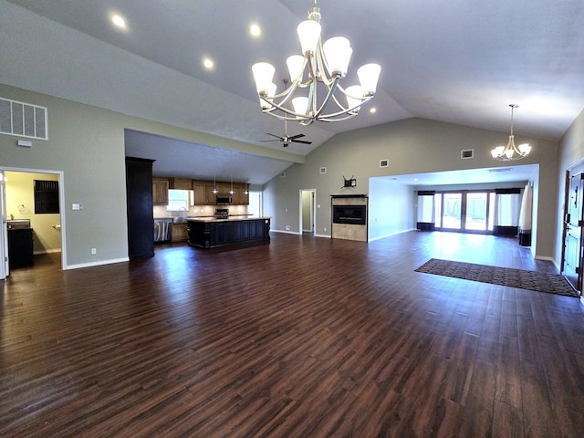 3410 Humble Ave, Midland, TX 79707 - unfurnished living room with a chandelier, a fireplace, baseboards, dark wood-type flooring, and high vaulted ceiling