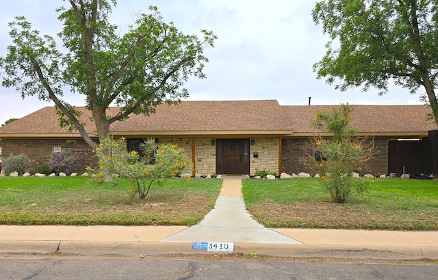 3410 Humble Ave, Midland, TX 79707 - ranch-style house with a front yard, roof with shingles, and stone siding