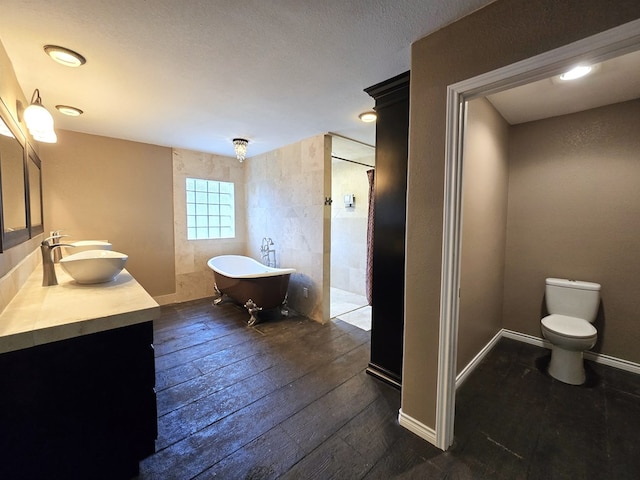 3410 Humble Ave, Midland, TX 79707 - full bath featuring double vanity, a freestanding bath, hardwood / wood-style flooring, and toilet