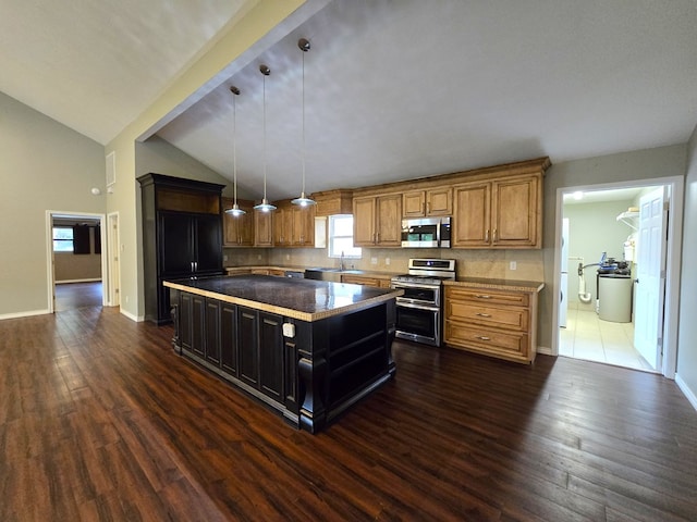 3410 Humble Ave, Midland, TX 79707 - kitchen with stainless steel appliances, a kitchen island, vaulted ceiling, dark wood-style flooring, and dark cabinets