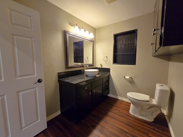 3410 Humble Ave, Midland, TX 79707 - bathroom with wood finished floors, baseboards, vanity, and toilet