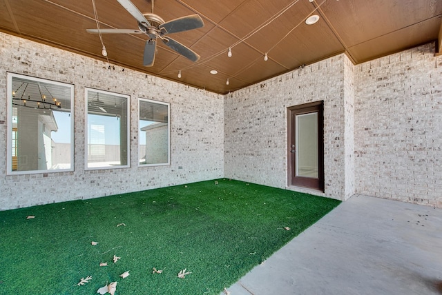 empty room featuring ceiling fan, concrete flooring, and wooden ceiling