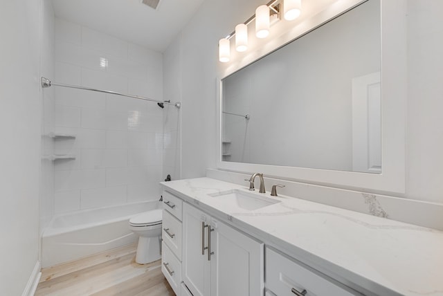 full bathroom with vanity, hardwood / wood-style flooring, toilet, and tiled shower / bath combo