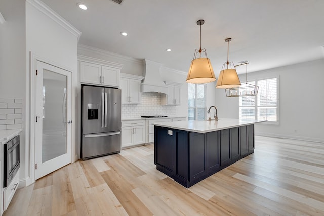 kitchen featuring white cabinets, hanging light fixtures, stainless steel fridge, and custom exhaust hood