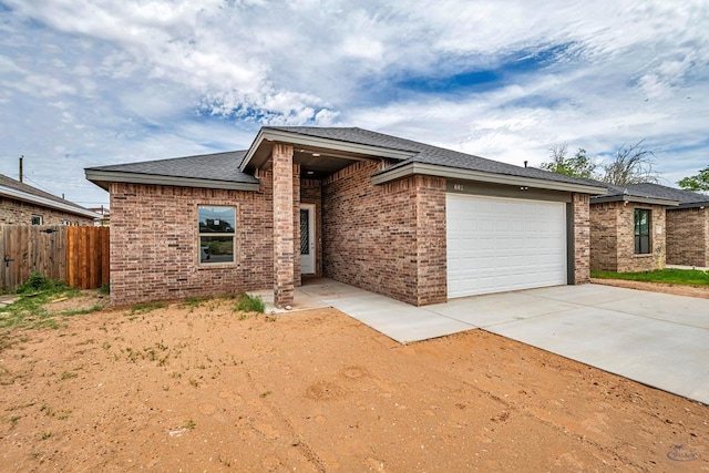 603 S Benton, Midland, TX 79701 - view of front of home with fence, a garage, brick siding, driveway, and roof with shingles