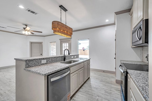 603 S Benton, Midland, TX 79701 - kitchen featuring stainless steel appliances, a sink, a center island with sink, baseboards, and ceiling fan