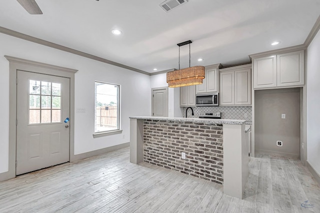 603 S Benton, Midland, TX 79701 - kitchen with stainless steel appliances, a center island with sink, backsplash, light wood-style flooring, and recessed lighting