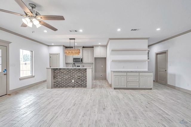 603 S Benton, Midland, TX 79701 - kitchen featuring stainless steel microwave, open shelves, ornamental molding, ceiling fan, and baseboards