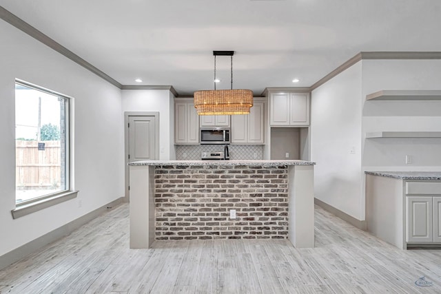 603 S Benton, Midland, TX 79701 - kitchen with stainless steel microwave, open shelves, decorative backsplash, light wood-style floors, and crown molding