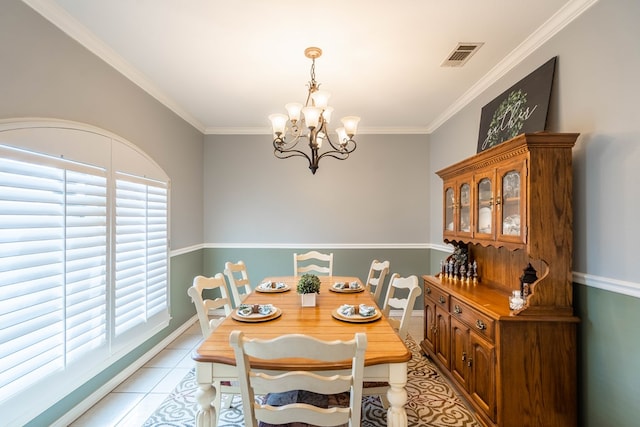 dining area featuring ornamental molding, a chandelier, and light tile patterned floors