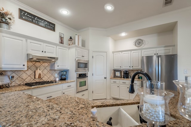 kitchen with light stone countertops, stainless steel appliances, and white cabinets