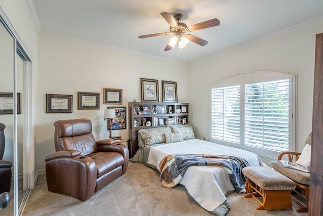 bedroom featuring ornamental molding, carpet, ceiling fan, and a closet