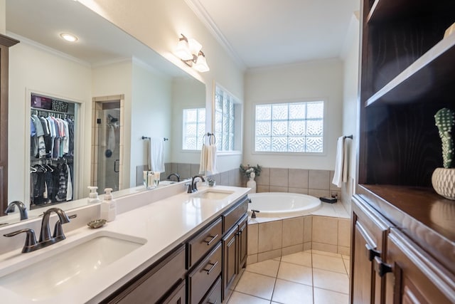 bathroom with tile patterned floors, ornamental molding, independent shower and bath, and vanity