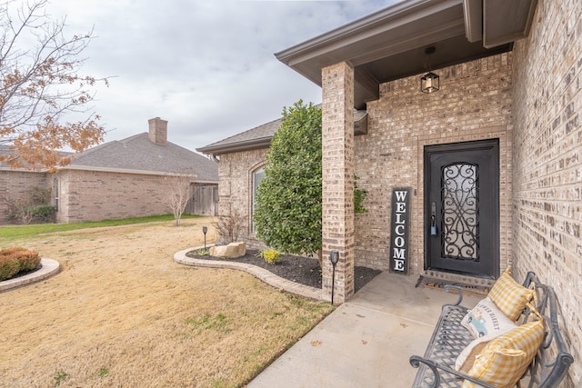 property entrance with a lawn