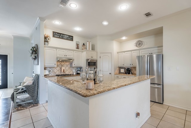 kitchen with white cabinetry, stainless steel appliances, light stone counters, and a center island with sink