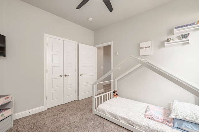 carpeted bedroom with ceiling fan, baseboards, and a closet