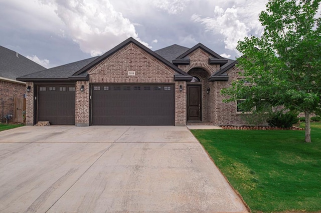 view of front of home featuring roof with shingles, brick siding, a front lawn, concrete driveway, and an attached garage
