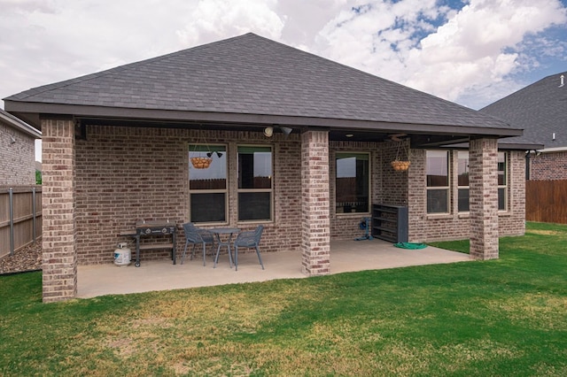 back of property featuring brick siding, fence, and a shingled roof