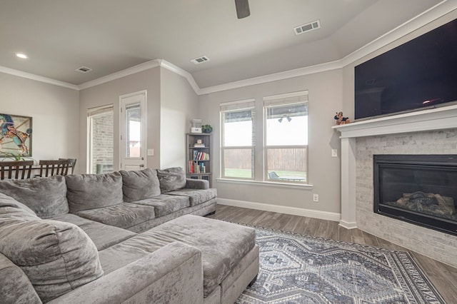 living room featuring visible vents, ornamental molding, and wood finished floors