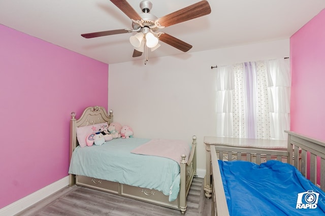 bedroom with ceiling fan, baseboards, and wood finished floors