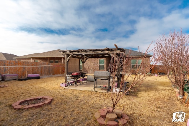 rear view of house featuring an outdoor fire pit, fence, a patio area, a pergola, and brick siding