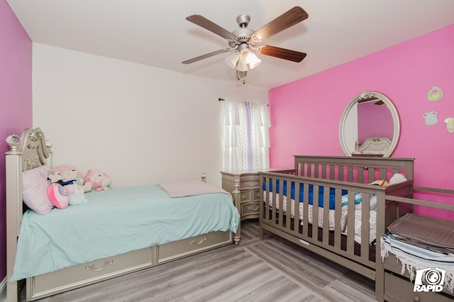 bedroom with light wood-style flooring and a ceiling fan