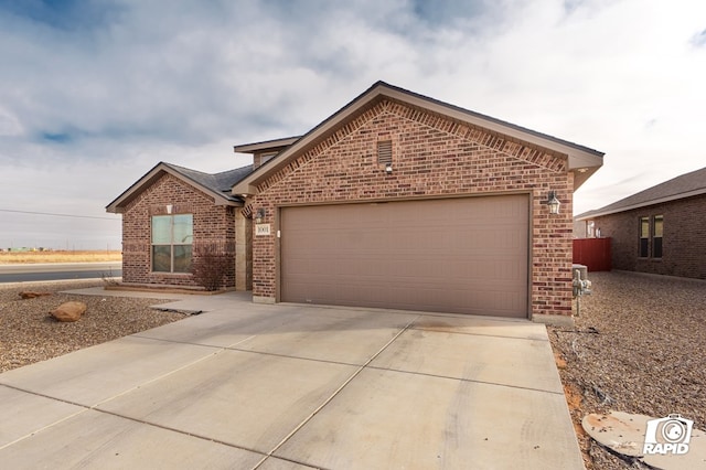 ranch-style house featuring brick siding, driveway, and an attached garage