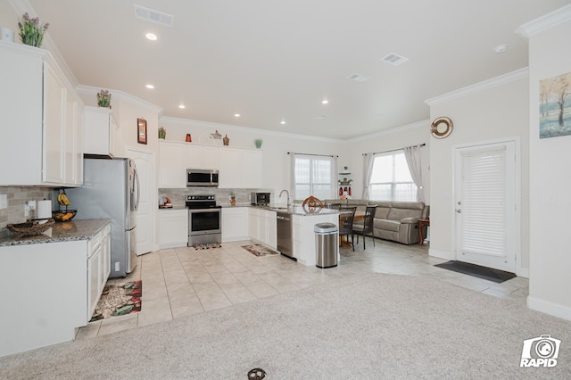 kitchen with visible vents, a breakfast bar area, open floor plan, stainless steel appliances, and white cabinetry