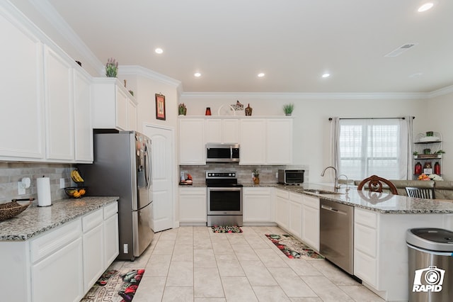 kitchen featuring a sink, white cabinetry, ornamental molding, appliances with stainless steel finishes, and light stone countertops