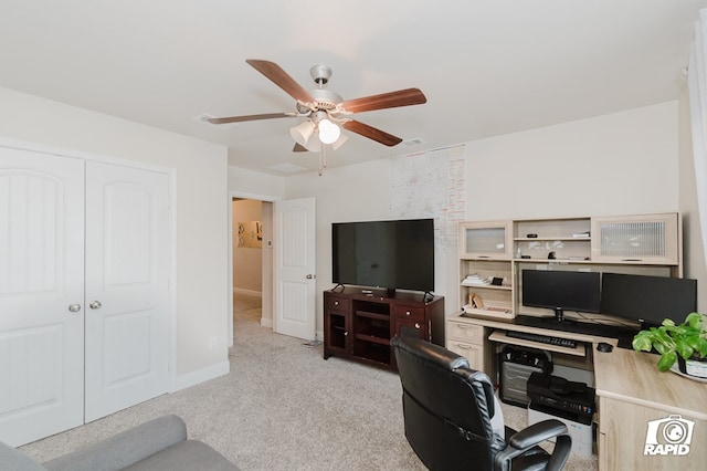 office space with a ceiling fan, light carpet, and baseboards