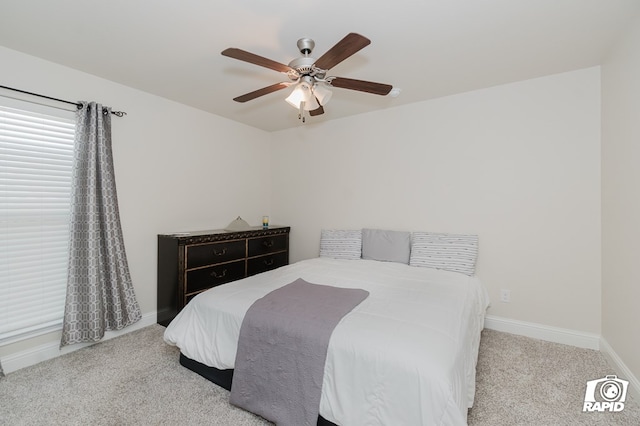 bedroom featuring baseboards, a ceiling fan, and light colored carpet