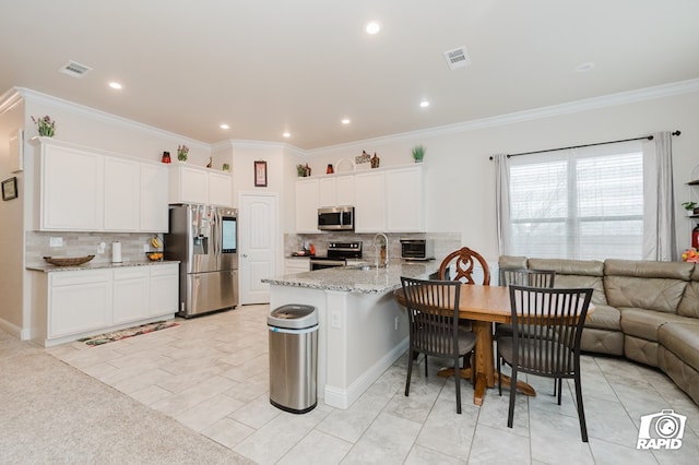 kitchen with open floor plan, stainless steel appliances, a peninsula, and white cabinetry