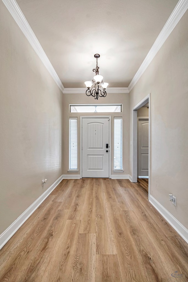 foyer with light wood-type flooring, ornamental molding, and a notable chandelier