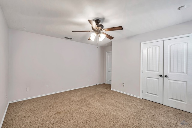 unfurnished bedroom with ceiling fan, carpet flooring, and a closet