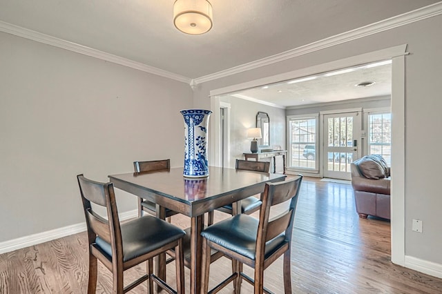 710 W Nobles Ave, Midland, TX 79701 - dining space featuring crown molding, wood finished floors, and baseboards
