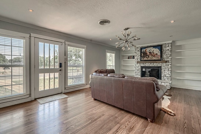 710 W Nobles Ave, Midland, TX 79701 - living area with a textured ceiling, ornamental molding, wood finished floors, built in shelves, and a chandelier