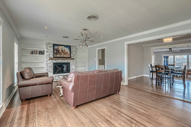 710 W Nobles Ave, Midland, TX 79701 - living room featuring baseboards, ornamental molding, light wood-style floors, a stone fireplace, and a chandelier